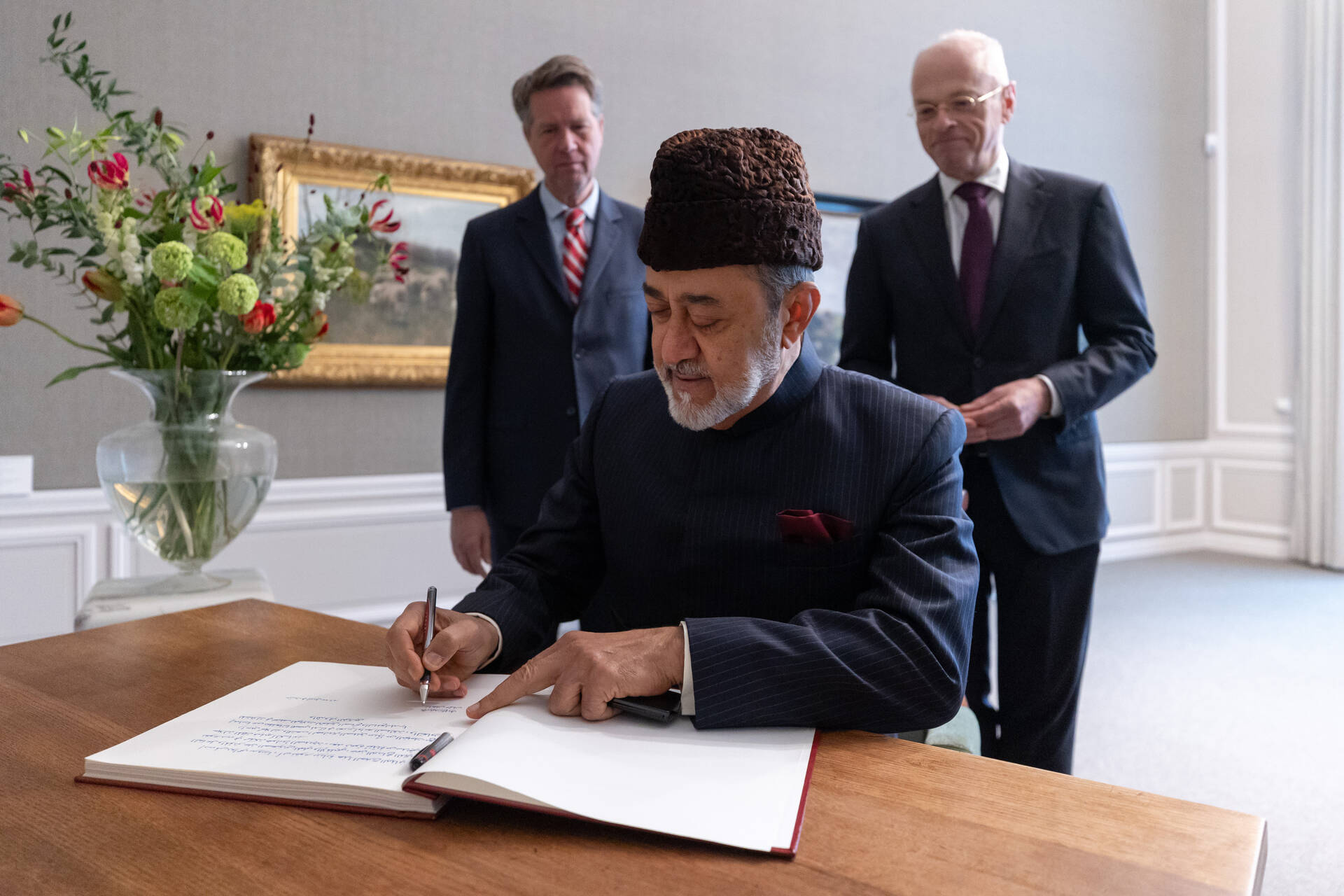 Sultan Haitham bin Tarik van Oman ondertekent het gastenboek.