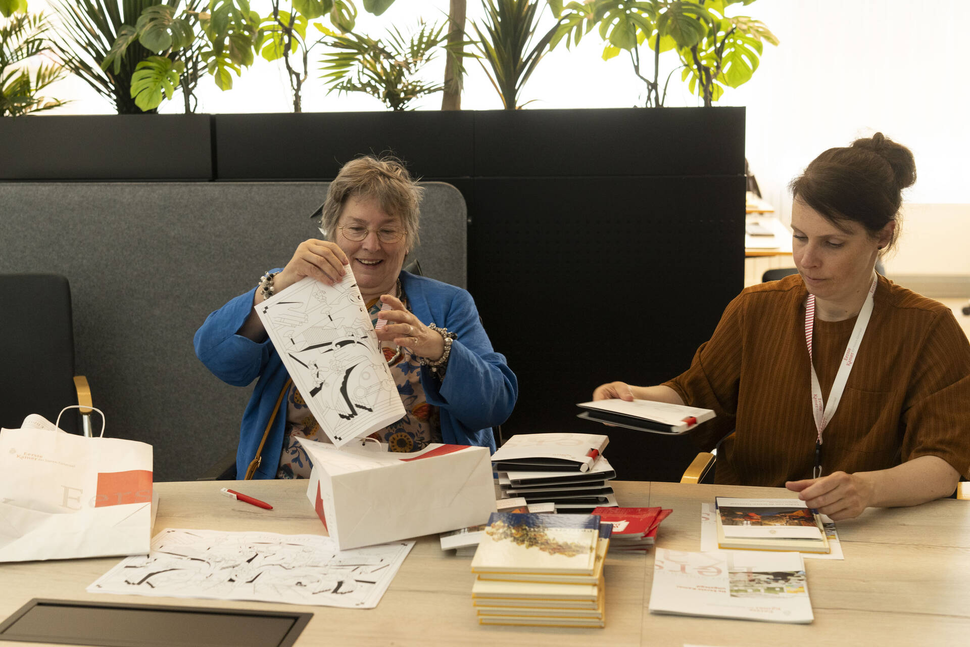 Stagiair Carola en haar coach Lineke helpen met het vullen van informatietasjes.